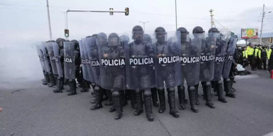 Polizisten rücken in Saquisili gegen Demonstranten vor. Es ist der erste Tag eines landesweiten Generalstreiks gegen den Anstieg der Benzinpreise und die Politik von Präsident Guillermo Lasso. Foto: Dolores Ochoa/AP/dpa
