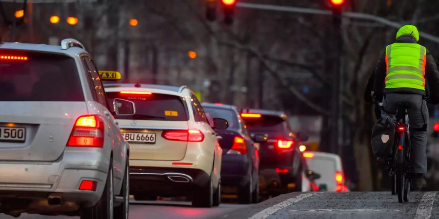 Viele Autos und ein Velofahrer.