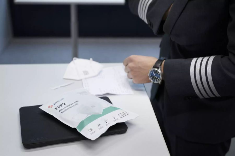 Eine Verpackung FFP2 Atemschutzmasken und ein Tablet liegen auf dem Tisch zu Beginn eines Piloten-Briefings vor einem Flug der Schweizer Fluggesellschaft Helvetic Airways von Zürich nach Wie