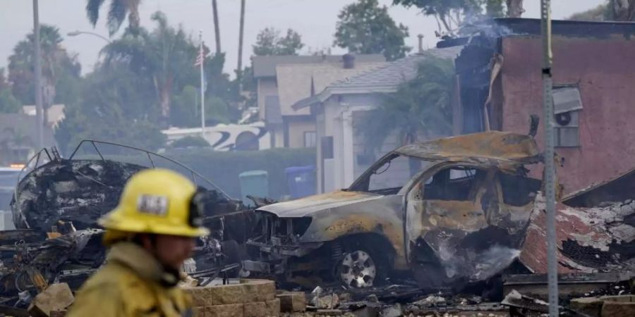 Feuerwehrleute arbeiten an der Absturzstelle des Kleinflugzeugs in Santee. Foto: Gregory Bull/AP/dpa