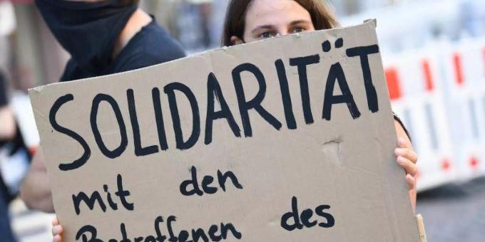 Eine Demonstrantin hält während einer Kundgebung in Wiesbaden ein Plakat mit der Aufschrift «Solidarität mit den Betroffenen des NSU 2.0» (Archiv). Die Staatsanwaltschaft hat gegen den mutmasslichen Verfasser der «NSU 2.0»-Drohschreiben Anklage erhoben. Foto: Arne Dedert/dpa Eine Demonstrantin hält während einer Kundgebung in Wiesbaden ein Plakat mit der Aufschrift «Solidarität mit den Betroffenen des NSU 2.0» (Archiv). Die Staatsanwaltschaft hat gegen den mutmasslichen Verfasser der «NSU 2.0»-Drohschreiben Anklage erhoben. Foto: Arne Dedert/dpa