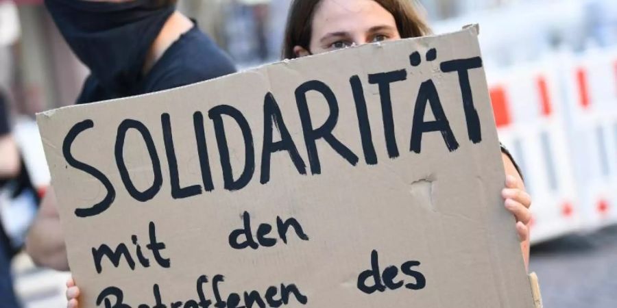 Eine Demonstrantin hält während einer Kundgebung in Wiesbaden ein Plakat mit der Aufschrift «Solidarität mit den Betroffenen des NSU 2.0» (Archiv). Die Staatsanwaltschaft hat gegen den mutmasslichen Verfasser der «NSU 2.0»-Drohschreiben Anklage erhoben. Foto: Arne Dedert/dpa