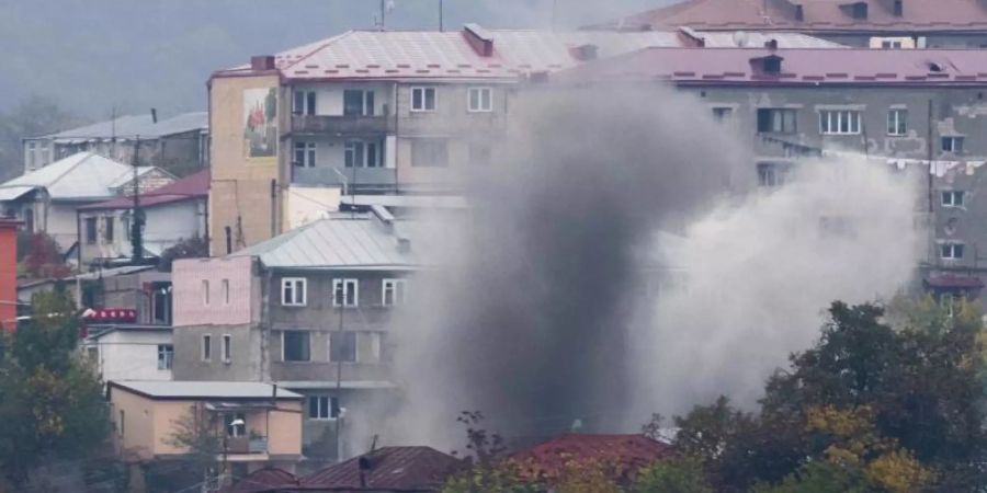 Rauch steigt nach dem Beschuss durch die aserbaidschanische Artillerie zwischen Gebäuden in Stepanakert auf. Foto: Uncredited/AP/dpa