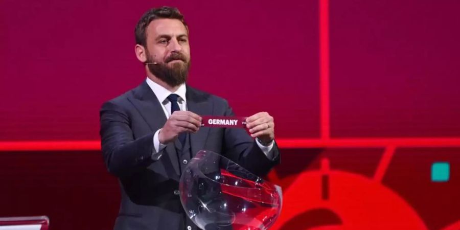 Der ehemalige Fussballspieler Daniele De Rossi zeigt das Los mit der Aufschrift «Germany». Foto: Kurt Schorrer/FIFA/dpa