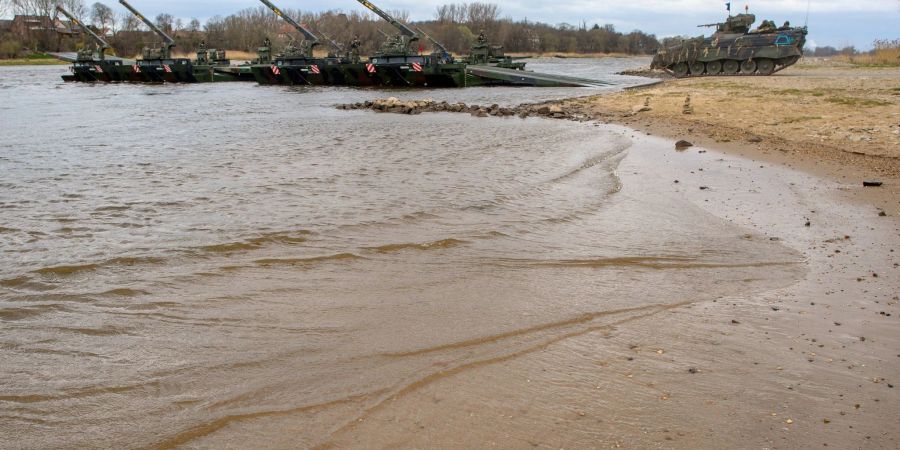 Ein Schützenpanzer vom Typ "Marder" fährt bei einer Bundeswehrübung am Elbestrand auf eine Schwimmschnellbrücke.