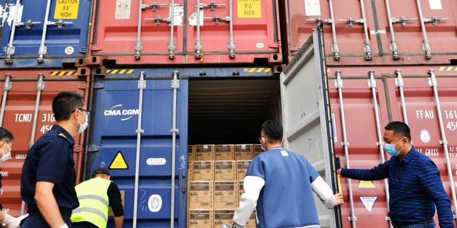 Mitarbeiter eines Frachtverteilzentrums in Xiamen kontrollieren Container vor deren Verschiffung. Foto: Wei Peiquan/XinHua/dpa