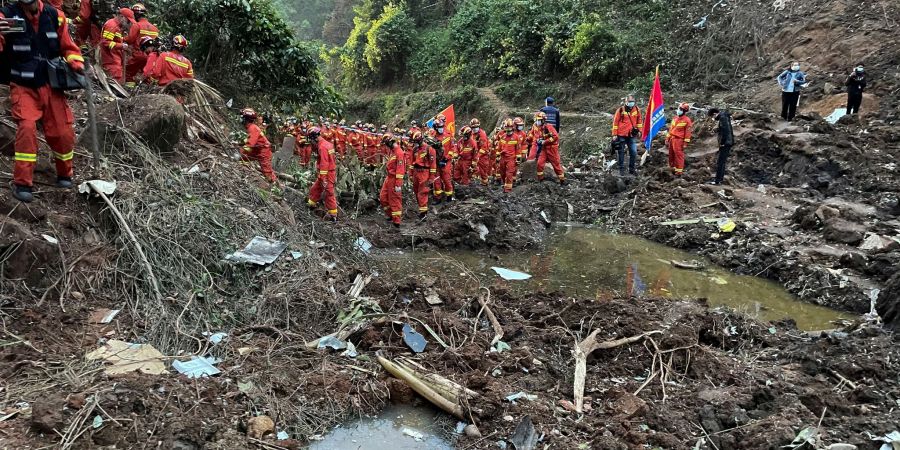 Auf diesem von der Nachrichtenagentur Xinhua veröffentlichten Foto führen Rettungskräfte Suchmassnahmen an der Absturzstelle der Boeing 737-800 durch.