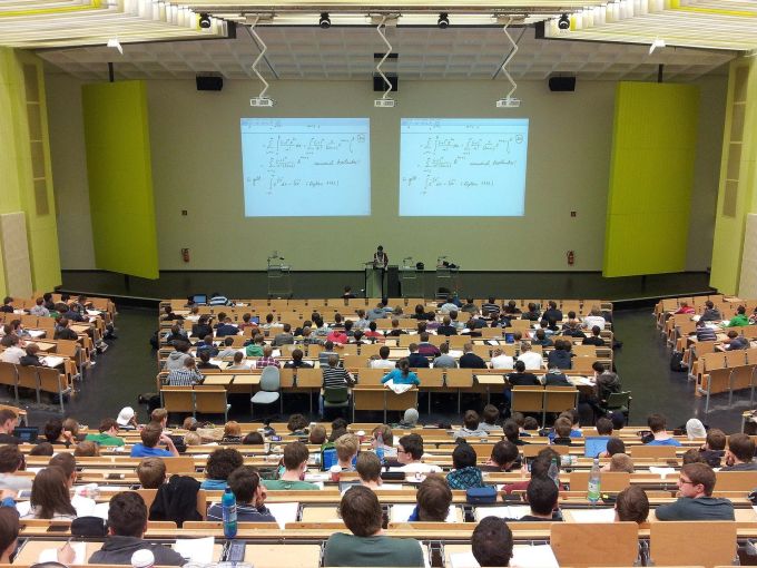 Die Präsenzeit an der Universität ist je nach Studiengang unterschiedlich. Hörsaal Studenten Bänke Vortrag