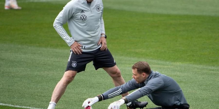 Deutschlands ehemaliger Torwarttrainer Andreas Köpke (l) und Torwart Manuel Neuer unterhalten sich während des Trainings. Foto: Federico Gambarini/dpa