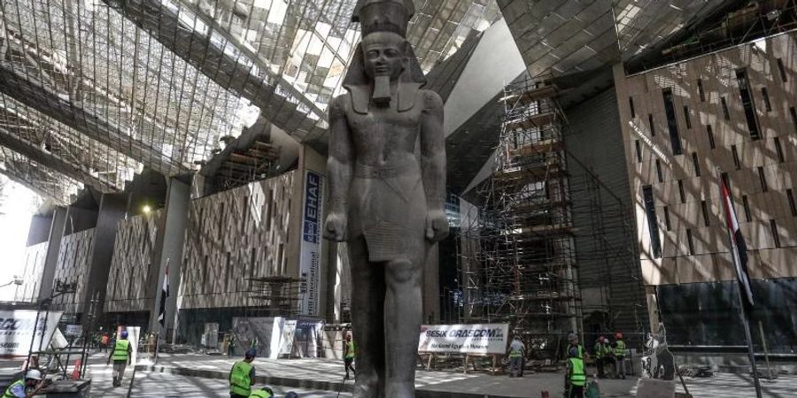 Arbeiter reinigen den Bereich neben der riesigen Statue des ägyptischen Pharaos Ramses II. in der Halle des Grossen Ägyptischen Museums. Foto: Hassan Mohamed/dpa