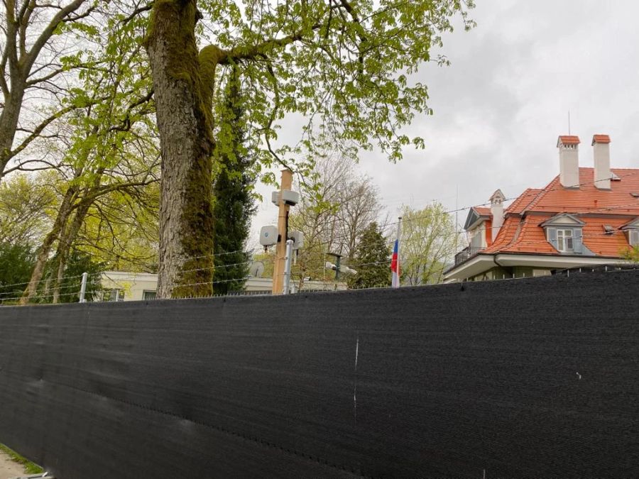 Zwischen dem Zaun und der Mauer der russischen Botschaft befindet sich ein Mast mit elektrischen Installationen,