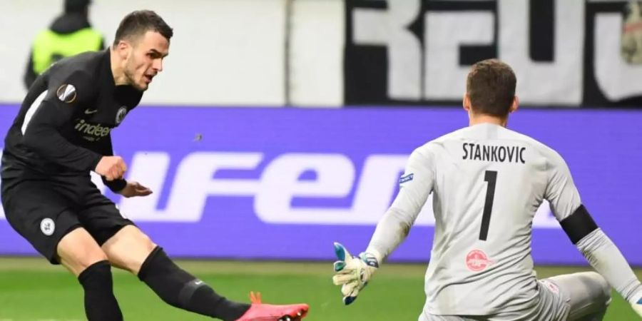 Eintracht hat ein gutes Polster für das Rückspiel in Salzburg: Frankfurts Filip Kostic (l) erzielt das Tor zum 4:0 gegen Salzburgs Torhüter Cican Stankovic. Foto: Arne Dedert/dpa