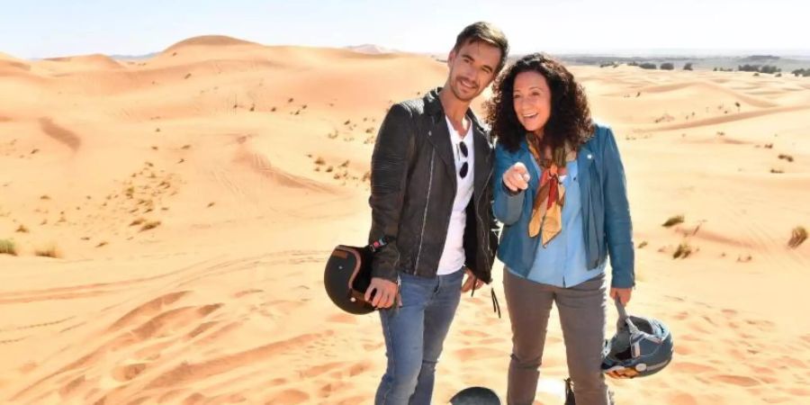 Hanna Liebhold (Barbara Wussow) ist es gelungen, Kapitän Max Parger (Florian Silbereisen) zu einem "Skiausflug" in die goldenen Sanddünen zu überreden. Foto: Dirk Bartling/ZDF/dpa