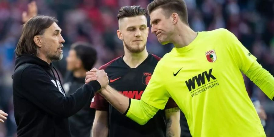 Augsburgs Trainer Martin Schmidt gratuliert Torwart Andreas Luthe zu einer starken Leistung. Foto: Sven Hoppe/dpa