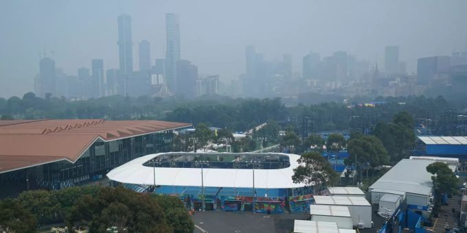 Rauch liegt über dem Melbourne Park, im Hintergrund der Central Business District der Stadt. Australian Open