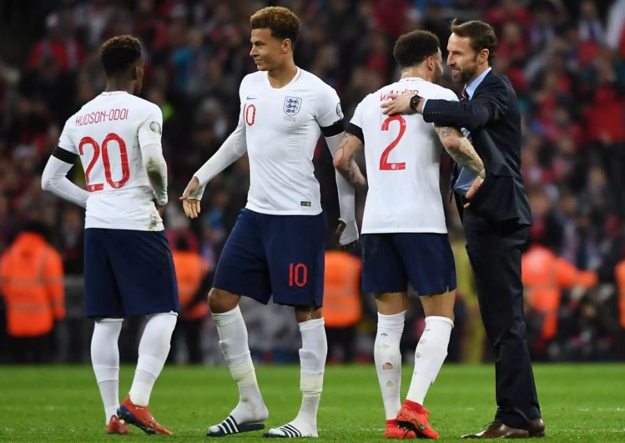 Gareth Southgate (r.) und Kyle Walker (2.v.r.) umarmen sich nach einem Sieg.