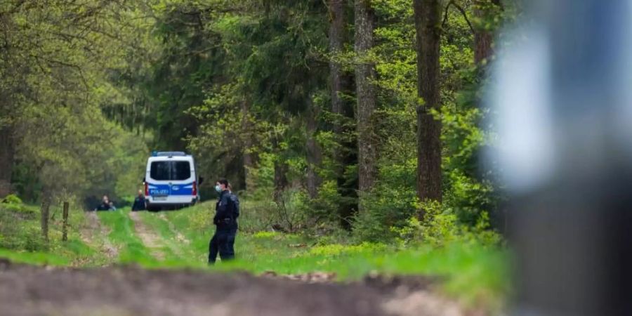 In einem Waldstück unweit von Bispingen sperren Polizisten den Fundort einer Kinderleiche ab. Foto: Philipp Schulze/dpa