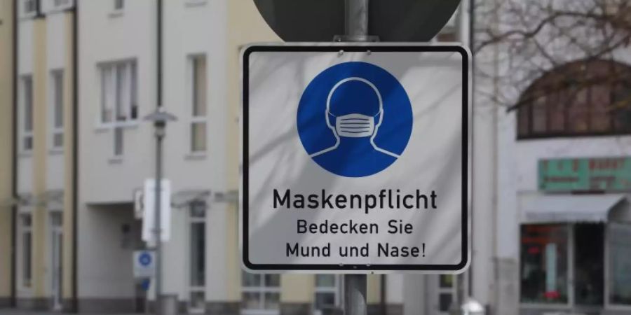 Ein Hinweisschild zur Maskenpflicht steht an der Fussgängerzone. Foto: Bodo Schackow/dpa-Zentralbild/dpa