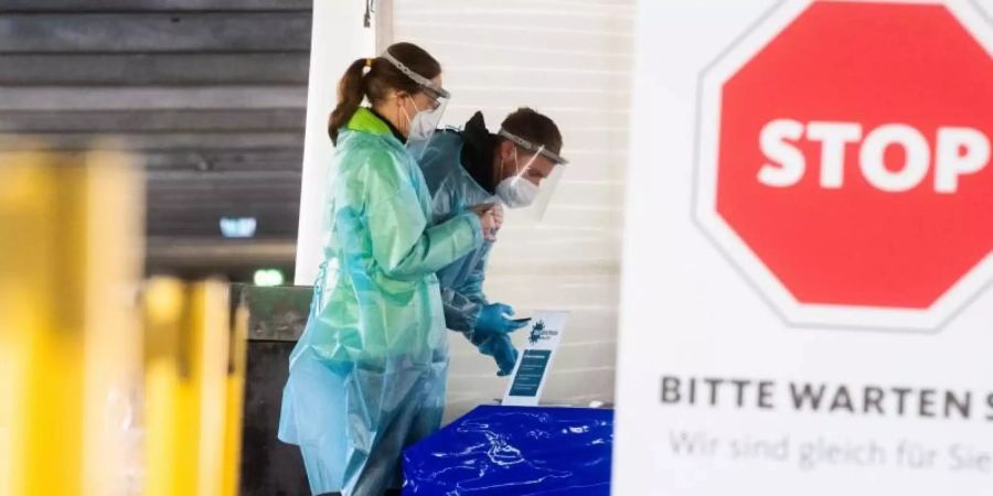 Helfer bereiten in Hannover Schnelltests auf das Coronavirus für Autofahrer vor. Foto: Julian Stratenschulte/dpa