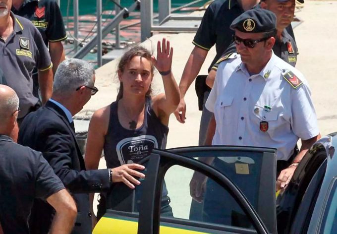 Carola Rackete (M), deutsche Kapitänin der «Sea-Watch 3», winkt, als sie nach ihrer Ankunft im Hafen von Porto Empedocle in ein Polizeifahrzeug steigt. Seenotrettung im Mittelmeer