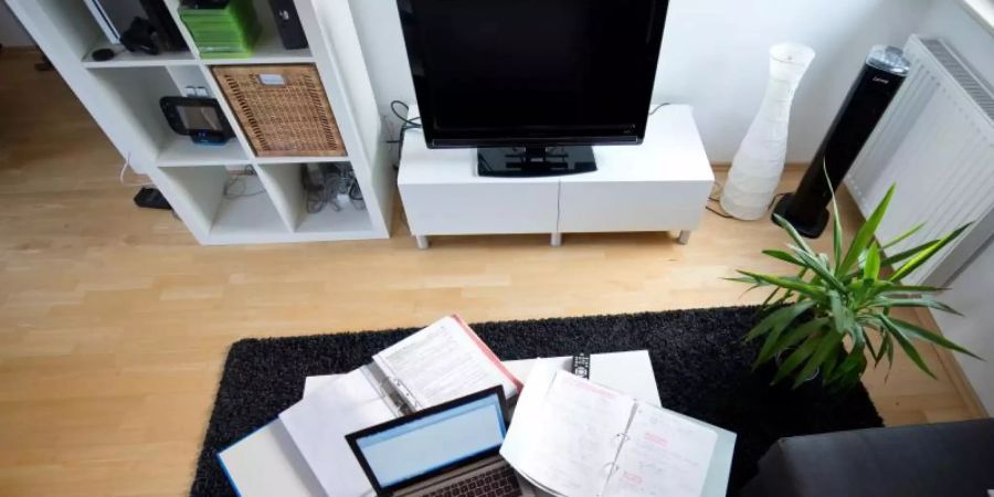 Zu Hause statt im Büro: Eine Frau arbeitet in einem Wohnzimmer an einem Laptop. Foto: Daniel Naupold