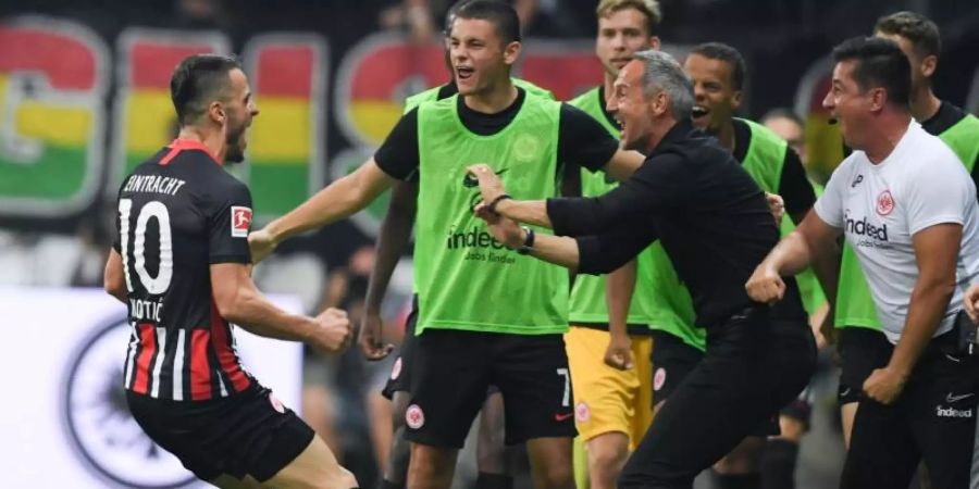 Frankfurts Torschütze Filip Kostic (l-r), Dejan Joveljic, Cheftrainer Adi Hütter und Co-Trainer Christian Peintinger jubeln nach dem Tor zum 2:0. Foto: Arne Dedert