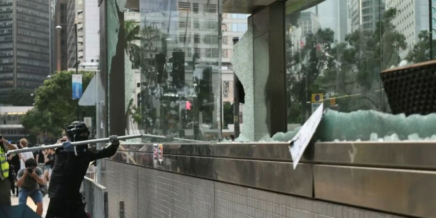 Demonstrant zerstört Glasfront einer U-Bahnstation