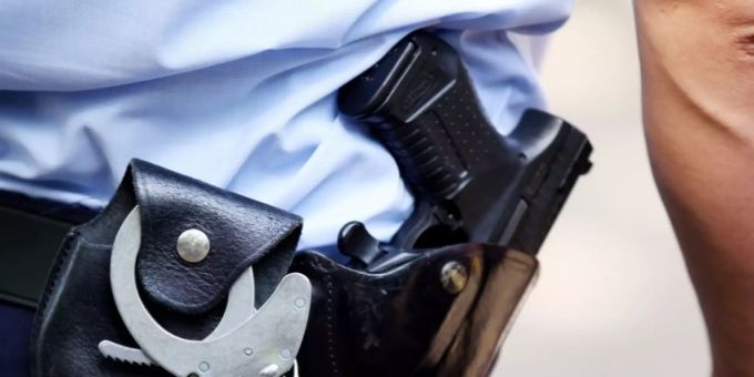 Polizist mit Handschellen und Dienstwaffe Polizist mit Handschellen und Dienstwaffe