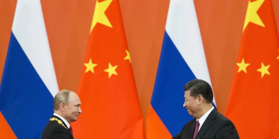 ARCHIV - Xi Jinping (r), Präsident von China, und Wladimir Putin, Präsident von Russland, schütteln sich die Hände während einer Preisverleihungszeremonie in der Grossen Halle des Volkes. Foto: Alexander Zemlianichenko/Pool AP/dpa