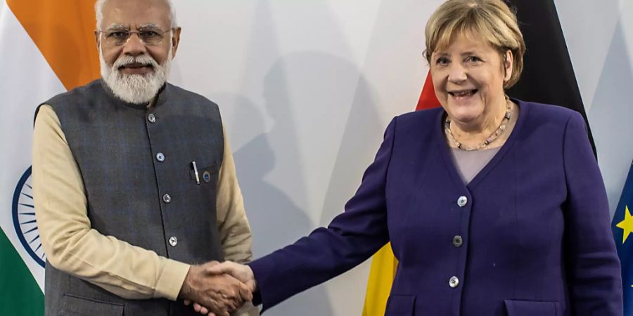 Narendra Modi, Premierminister von Indien, und Angela Merkel (CDU), geschäftsführende Bundeskanzlerin, reichen sich vor einem bilateralen Gespräch am Rande eines G20-Gipfels die Hände. Foto: Oliver Weiken/dpa