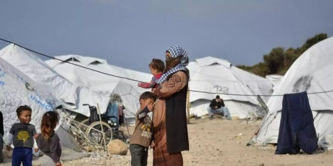 Eine Frau steht mit einem Baby im Arm und drei kleinen Kindern im Flüchtlingslager Kara Tepe in der Nähe von Mytilini auf Lesbos zwischen Zelten. Foto: Panagiotis Balaskas/AP/dpa Eine Frau steht mit einem Baby im Arm und drei kleinen Kindern im Flüchtlingslager Kara Tepe in der Nähe von Mytilini auf Lesbos zwischen Zelten. Foto: Panagiotis Balaskas/AP/dpa