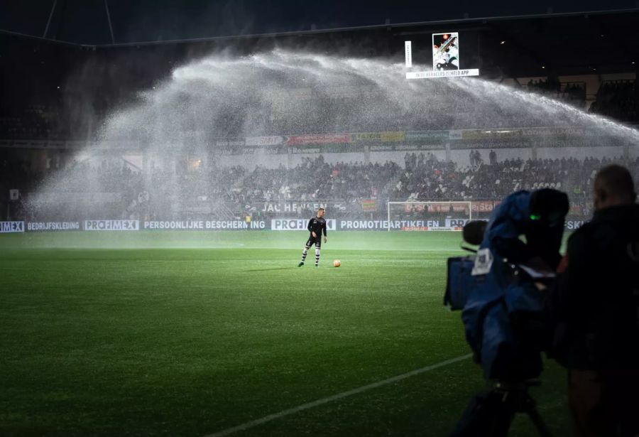 Fussballer allein Spielfeld Ball Wasserstrahler