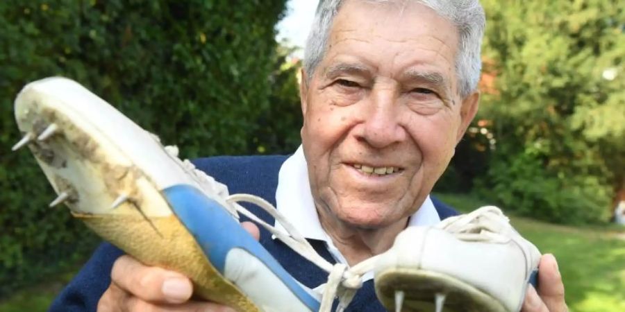 Heinz Fütterer posiert mit alten Laufschuhen aus dem Jahr 1957. Foto (2016): Uli Deck Foto: Uli Deck