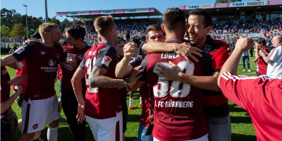 Fans und Spieler jubel über den Aufstieg des 1. FC Nürnberg.