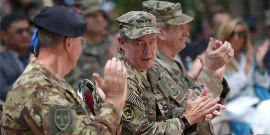 General Scott Miller redet mit einem Kollegen und klatscht in die Hände während der Zeremonie in Kabul.