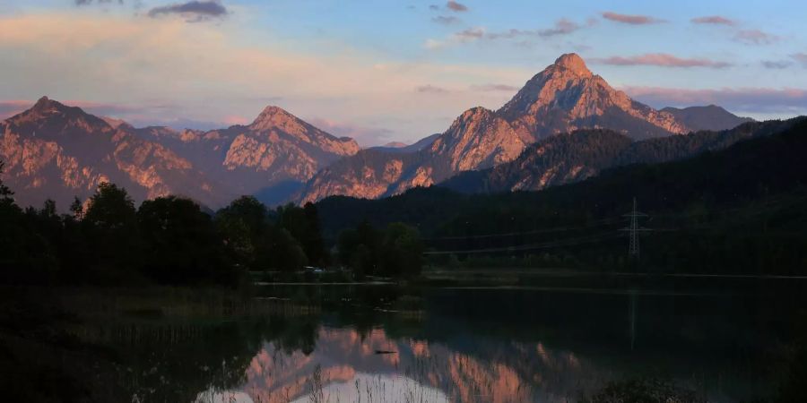 Der Tegelberg (links) und der Säuling (rechts) spiegeln sich im Weissensee.