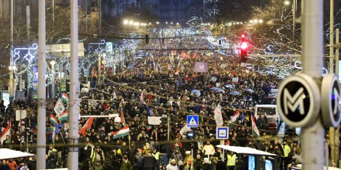 Teilnehmer einer Demonstration gegen die Regierung marschieren unter der Weihnachtsdekoration im Stadtzentrum entlang.