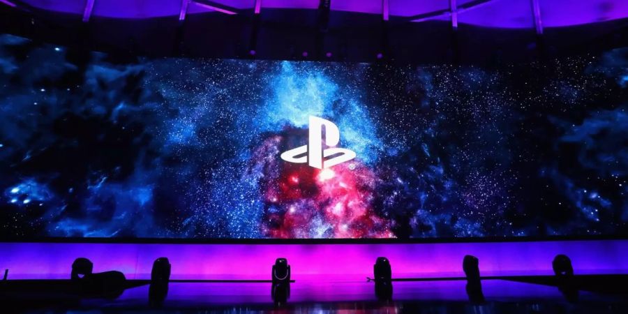 Das PlayStation Logo vor einem Weltraum-Hintergrund auf einer Bühne.