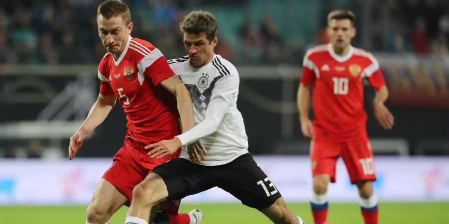 Thomas Müller (r) aus Deutschland und Andrej Semenow aus Russland kämpfen um den Ball.