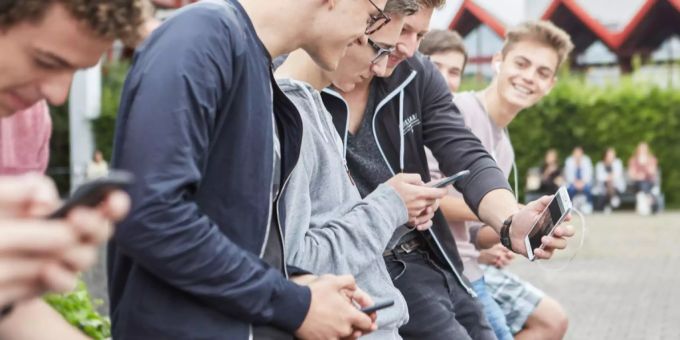 Schüler auf dem Pausenhof mit ihren Smartphones. (Symbolbild) Schule