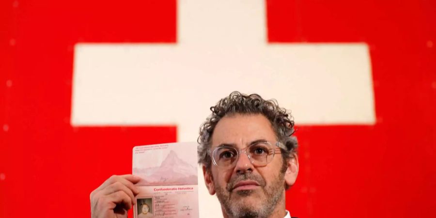 Der Künstler Tom Sachs posiert mit einem Fake-Schweizer Pass während seiner Live-Performance Swiss Passport Office in der Galerie Thaddaeus Ropac in London.