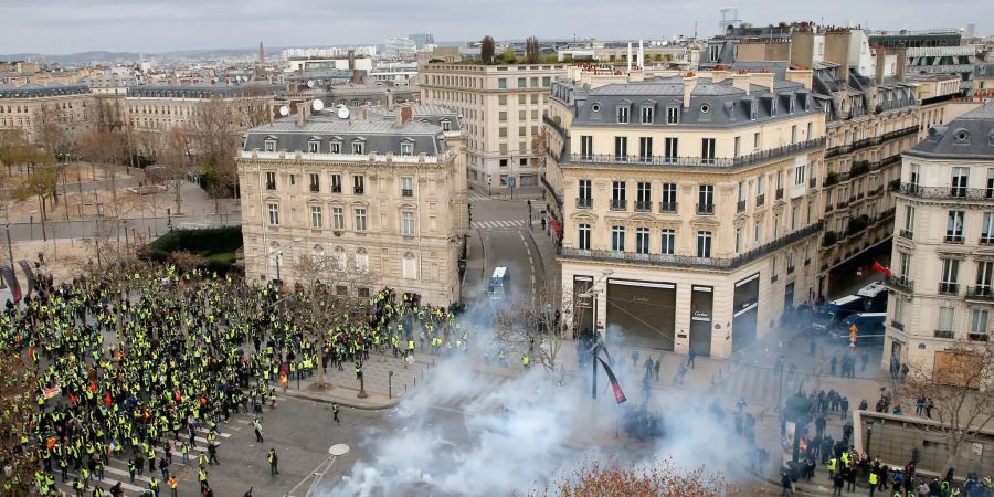 Gelbwesten-Demonstranten und Einsatzkräfte an der Champs-Elysees.