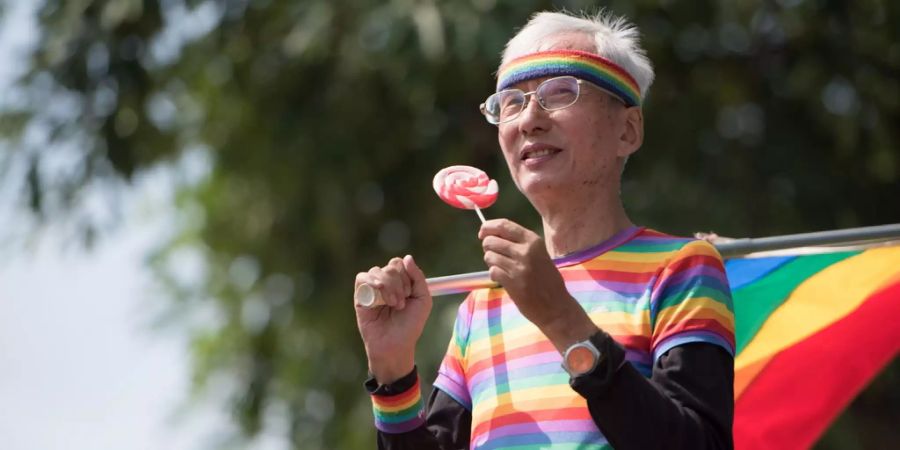 Ein Aktivist hält in Taiwan an der Gay-Pride-Parade eine Regenbogen-Flagge.