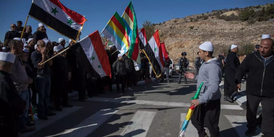 Drusen halten syrische und drusische Flaggen als Protest während der Kommunalwahl in Israel.