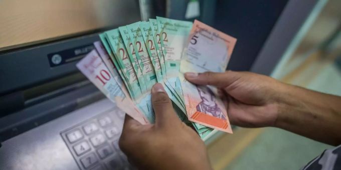 Eine Person bezieht in Caracas Bolívar von einem Geldautomaten. Eine Person bezieht in Caracas Bolívar von einem Geldautomaten.