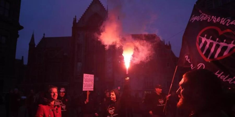 Menschen bei einer Demonstration gegen die Covid-19-Beschränkungen in Amsterdam teil. Nach den heftigen Ausschreitungen in Rotterdam haben Randalierer in verschiedenen Städten der Niederlande für Unruhen gesorgt. Foto: Peter Dejong/AP/dpa