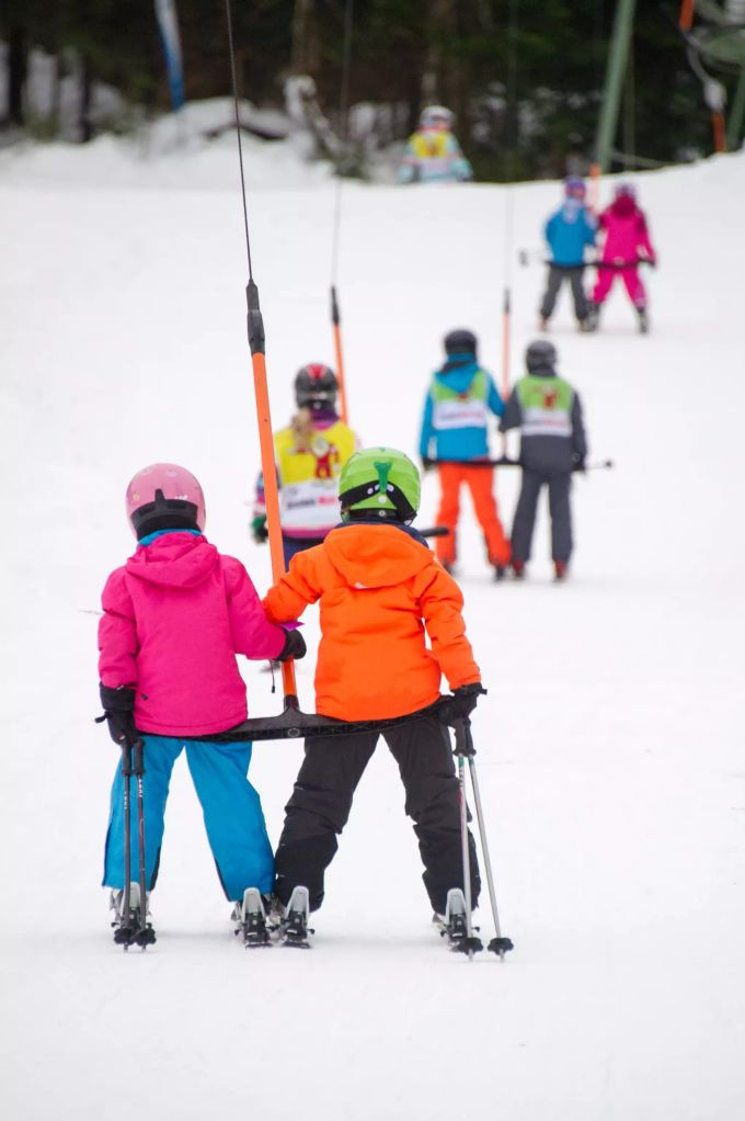 Skikurs in den Alpen: Diese Kinder kommen den Schlepplift mit ihren Ski schon problemlos hoch. Schnee Kinder Ski Schlepplift