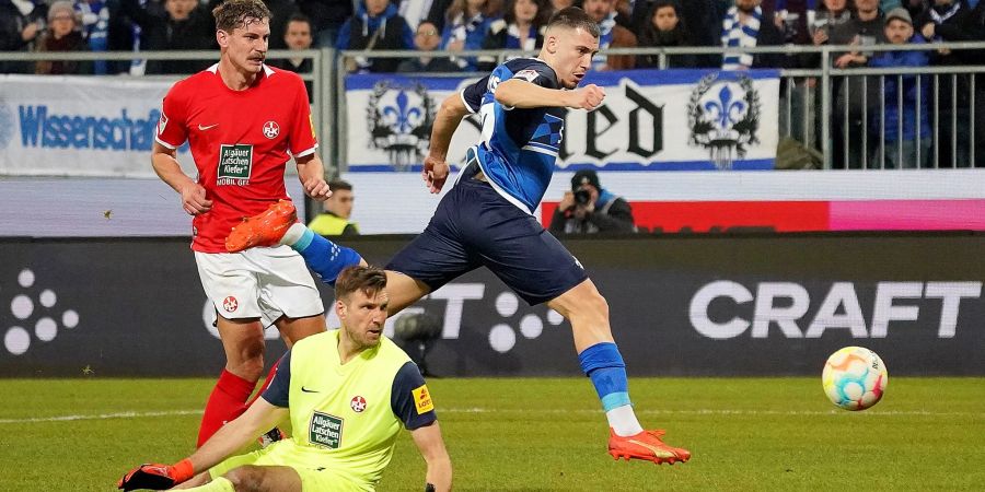 Darmstadts Filip Stojilkovic (r) erzielt den Treffer zum 2:0. Kaiserslauterns Kevin Kraus (l) und Torwart Andreas Luthe (M) schauen hinterher.