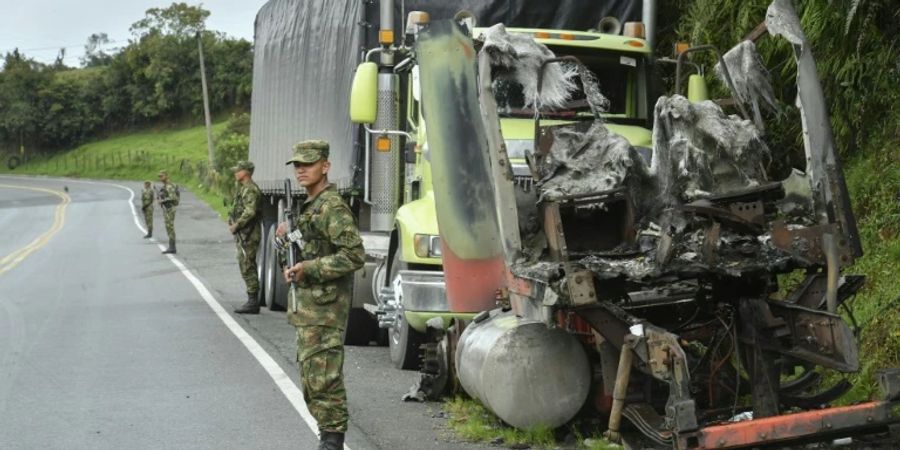 Soldaten vor verbranntem Lkw in Kolumbien