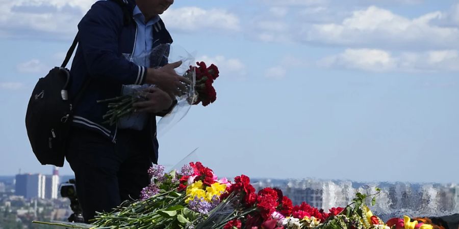 Ein Mann legt anlässlich des «Tag des Sieges» Blumen an einem Grabmal nieder. Inmitten des russischen Angriffskrieges haben in der Ukraine viele Menschen still der Toten des Zweiten Weltkriegs gedacht. Foto: Efrem Lukatsky/AP/dpa